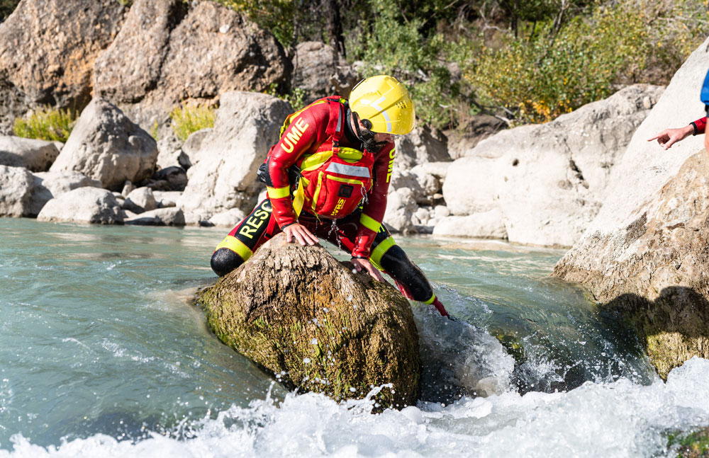 Un activo de la UME avanzando por el río con el material de rescate